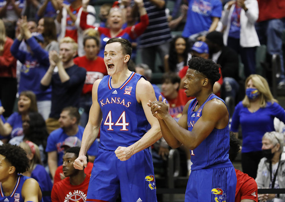 Kansas forward Mitch Lightfoot, left, and teammate Joseph Yesufu cheer their team during the first half of an NCAA college basketball game against Iona, Sunday, Nov. 28, 2021, in Lake Buena Vista, Fla. (AP Photo/Jacob M. Langston)