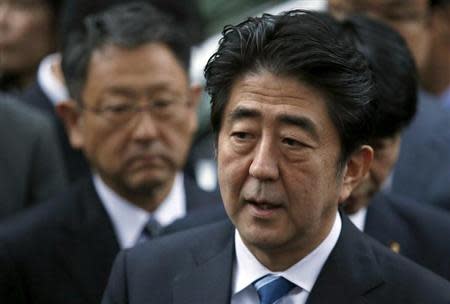 Japan's Prime Minister Shinzo Abe speaks to the media in front of Toyota Motor Corp's President Akio Toyoda (L) after taking part in the Japanese automakers' autonomous driving car test in Tokyo November 9, 2013. REUTERS/Yuya Shino/Files