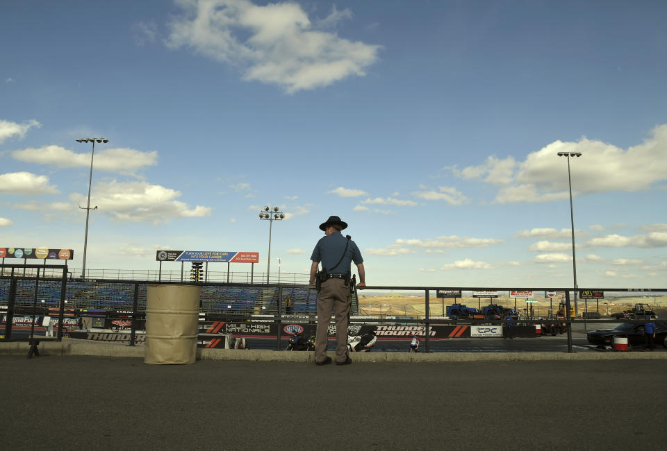 Colorado State Patrol Trooper Josh Lewis waits for racing to begin at Bandimere Speedway west of Denver on May 5, 2021. The State Patrol runs a program called "Take it to the Track" in hopes of luring racers away from public areas to a safer and more controlled environment, even allowing participants to race a trooper driving a patrol car. The program's goals have gained new importance and urgency this year as illegal street racing has increased amid the coronavirus pandemic. "Take it to the Track" is open to anyone who wants to race, regardless of vehicle or ability. (AP Photo/Thomas Peipert)