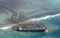 This photo taken and provided by Eric Villars shows oil leaking from the MV Wakashio, a bulk carrier ship that recently ran aground off the southeast coast of Mauritius, Friday, Aug. 7, 2020. Anxious residents of the Indian Ocean island nation of Mauritius are stuffing fabric sacks with sugar cane leaves to create makeshift oil spill barriers as tons of fuel leak from a grounded ship. The government has declared an environmental emergency and France says it is sending help from its nearby Reunion island. (Eric Villars via AP)