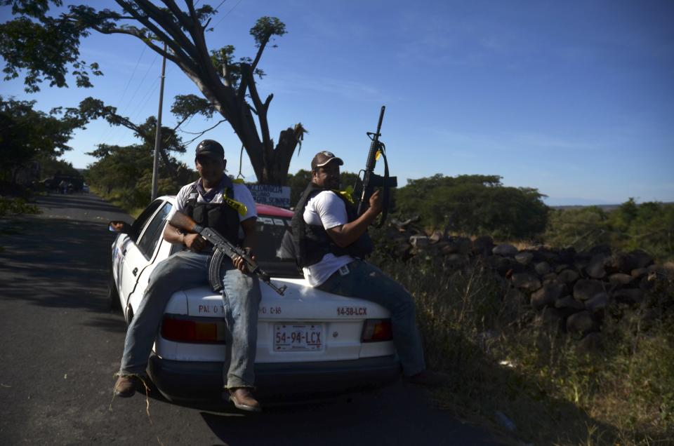 Members of the community police, acting in this case as vigilantes, patrol on a highway near the village of Paracuaro in Michoacan state