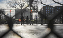 People play basketball in Brooklyn's Hamilton Metz Field on Tuesday, March 24, 2020, in New York. Mayor Bill de Blasio said that the NYPD and other city agencies would be out in force at parks to warn and educate people who fail to maintain social distancing during the coronavirus outbreak. (AP Photo/Bebeto Matthews)