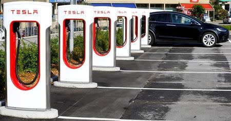 FILE PHOTO: An electric-powered Tesla car stands at a charging station in Melide near Lugano, Switzerland May 9, 2018. REUTERS/Arnd Wiegmann/File Photo