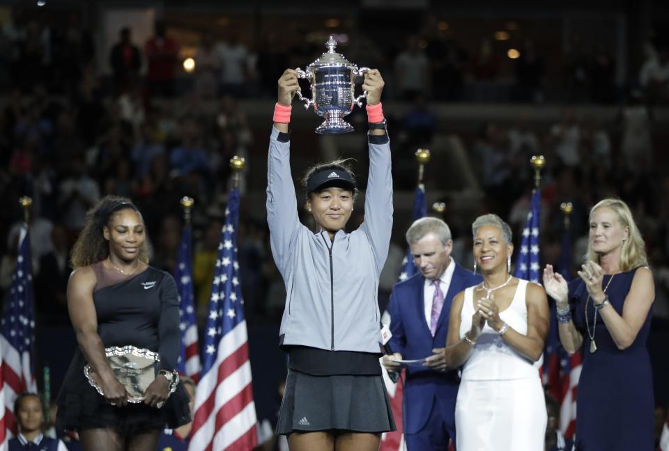 FILE - In this Sept. 8, 2018, file photo, Naomi Osaka, of Japan, holds the trophy after defeating Serena Williams in the women's final of the U.S. Open tennis tournament, in New York. Caroline Wozniacki will be defending a Slam title for the first time after winning in Melbourne a year ago, while Naomi Osaka will enter a major tournament with the label “major champion” for the first time after taking home the trophy at the U.S. Open in September.(AP Photo/Julio Cortez, File)