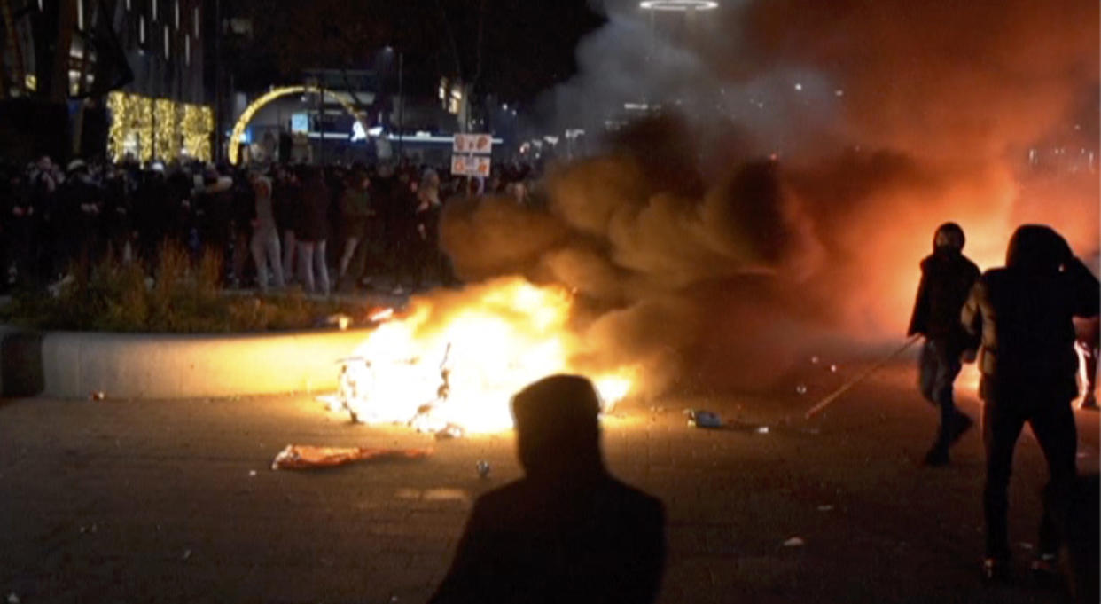 In this image taken from video, demonstrators protest against government restrictions due to the coronavirus pandemic, Friday, Nov. 19, 2021, in Rotterdam, Netherlands. Police fired warning shots, injuring an unknown number of people, as riots broke out Friday night in downtown Rotterdam at a demonstration against plans by the government to restrict access for unvaccinated people to some venues. (Media TV Rotterdam via AP)