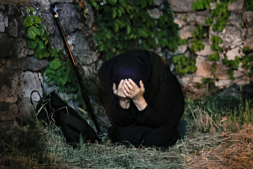 An orthodox worshiper kneels during a religious service in the Black Sea port of Constanta, Romania, late Tuesday, May 26, 2020. (AP Photo/Vadim Ghirda)