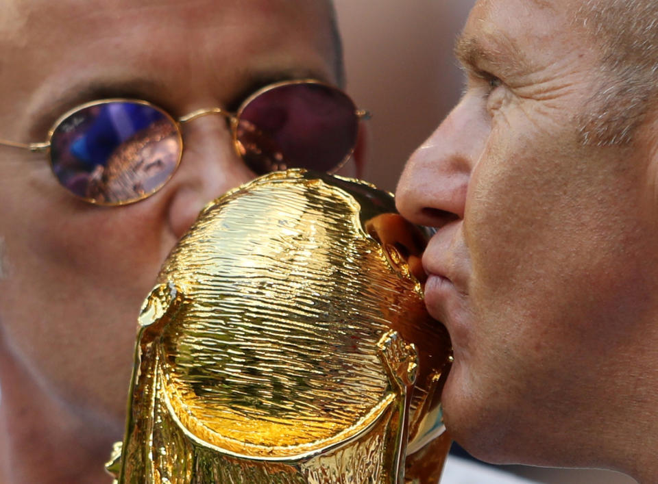 <p>Fans kiss a World Cup replica inside the stadium before the match </p>