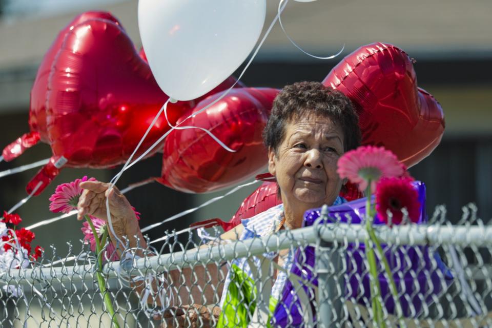 Mercy Aguirre ties balloons in memory of her longtime colleague Lucy Reyes.