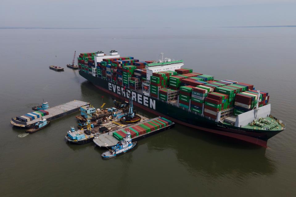 Barges are seen near the container ship Ever Forward, right, which ran aground last month, as workers remove containers from it in efforts to lighten the load and refloat the vessel.