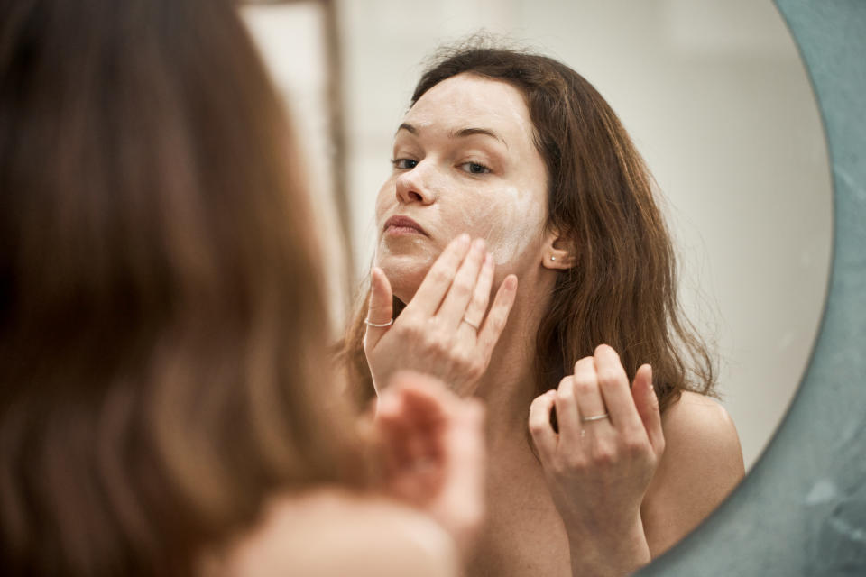 a person putting cream on their face