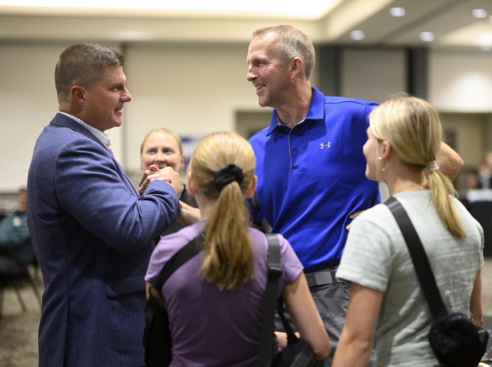 Republican Congressional candidate Brad Finstad, left, shakes hands with longtime friend, Steve Gilles, right, during an election night party for Finstad, Tuesday, Aug. 9, 2022, at the Sleepy Eye Event Center in Sleepy Eye, Minn. Finstad has won the special election to U.S. House in Minnesota's 1st Congressional District. (Aaron Lavinsky/Star Tribune via AP)