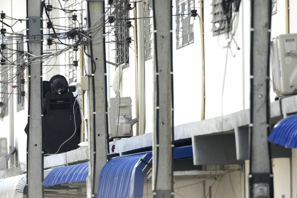 An armed commando police is seen outside the home balcony of a senior police officer on second floor in Bangkok, Thailand, Wednesday, March 15, 2023. Thai police have arrested a fellow officer who fired multiple gunshots from his home in Bangkok which forced an over 24 hours-long standoff after his colleagues tried to take him to be treated for mental illness. (AP Photo/Sakchai Lalit)