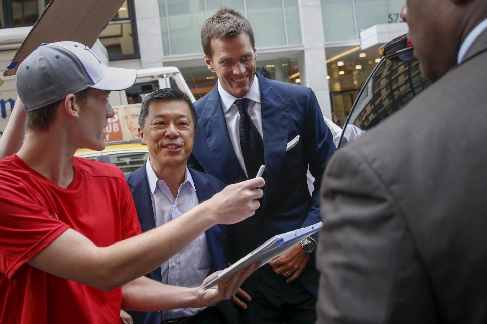 New England Patriots quarterback Tom Brady (C) arrives at NFL headquarters as people ask for autographs in New York June 23, 2015. Brady's appeal of his four-game National Football League suspension for participating in a scheme to deflate footballs during last season's playoffs begins Tuesday at NFL headquarters in New York. REUTERS/Shannon Stapleton