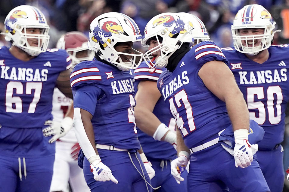 Kansas running back Devin Neal (4) and tight end Jared Casey (47) celebrate after Neal scored a touchdown during the second half of an NCAA college football game against Oklahoma Saturday, Oct. 28, 2023, in Lawrence, Kan. Kansas won 38-33. (AP Photo/Charlie Riedel)