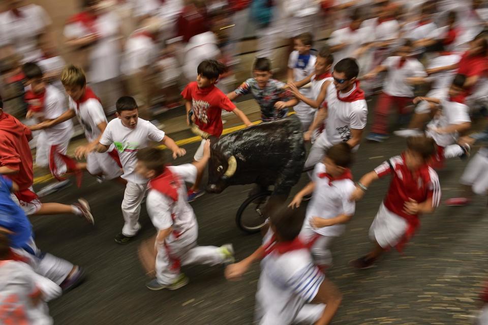 <p>Boys run next to a toy bull imitating the running of the bull, during the ”Encierro Txiki”, just for young runners, during the San Fermin Festival, in Pamplona, northern Spain, July 10, 2017. (AP Photo/Alvaro Barrientos) </p>