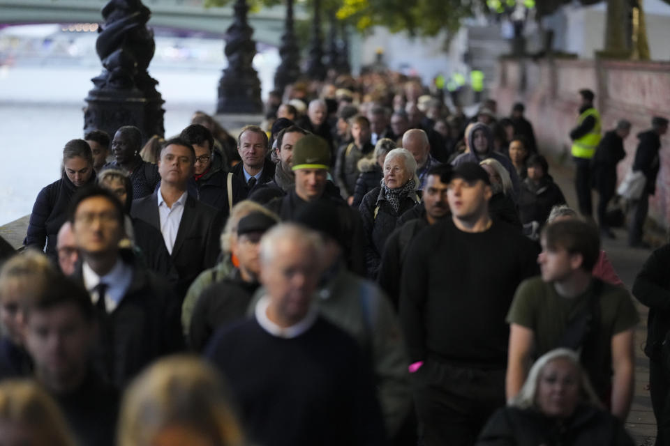 People queue to pay their respect to the late Queen Elizabeth II during the Lying-in State, at Westminster Hall in London, Thursday, Sept. 15, 2022. The Queen will lie in state in Westminster Hall for four full days before her funeral on Monday Sept. 19. (AP Photo/Markus Schreiber)