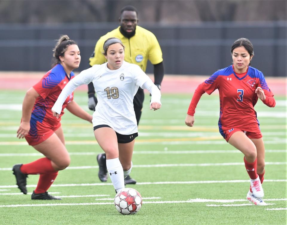 Abilene High's Rheauna De La Garza, center, goes on the attack as Cooper's Anita Alcantar (3) gives chase. De La Garza scored on the play for the game's first goal with 19:49 left in the first half.