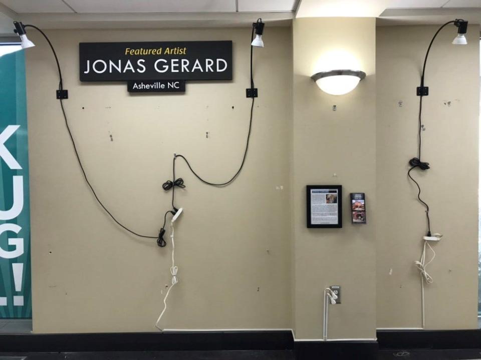 An advertising display at the Asheville Regional Airport for Jonas Gerard is bare Tuesday following two acts of vandalism. The artist has been accused of sexual assault, which Gerard denies.