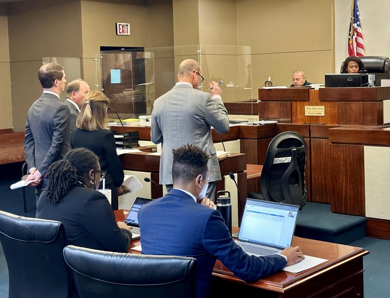 Gabriel and Sarah Warren, standing at the lectern behind their attorneys, Fred Conrad and Robert "Alex" Morris, enter no contest pleas to criminal use of a two-way communication device during a hearing Thursday before Leon Circuit Judge Tiffany Baker-Carper.