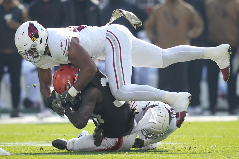 Cleveland Browns running back Jerome Ford, middle, is tackled by Arizona Cardinals linebacker Zaven Collins, top, and cornerback Starling Thomas V during the first half of an NFL football game Sunday, Nov. 5, 2023, in Cleveland. (AP Photo/Sue Ogrocki)