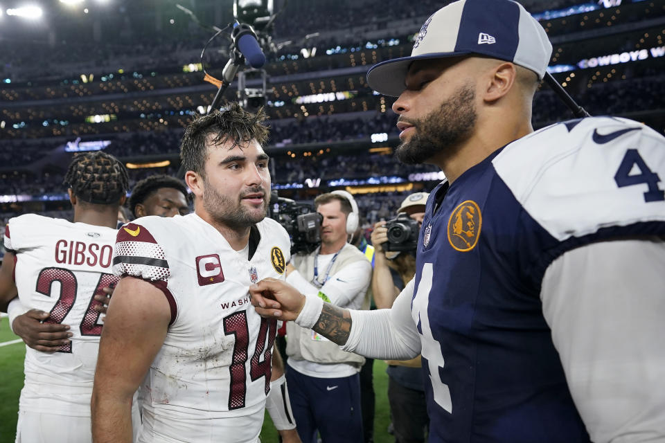 Washington Commanders quarterback Sam Howell (14) talks to Dallas Cowboys quarterback Dak Prescott (4) after an NFL football game Thursday, Nov. 23, 2023, in Arlington, Texas. (AP Photo/Sam Hodde)