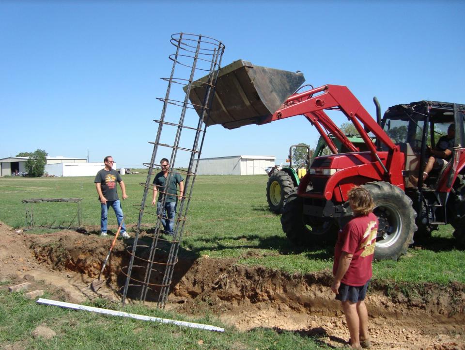 A digger and the support beams to create a foundation for the house.