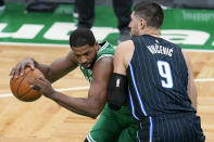 Boston Celtics forward Tristan Thompson, left, drives against Orlando Magic center Nikola Vucevic during the first half of an NBA basketball game Friday, Jan. 15, 2021, in Boston. (AP Photo/Elise Amendola)