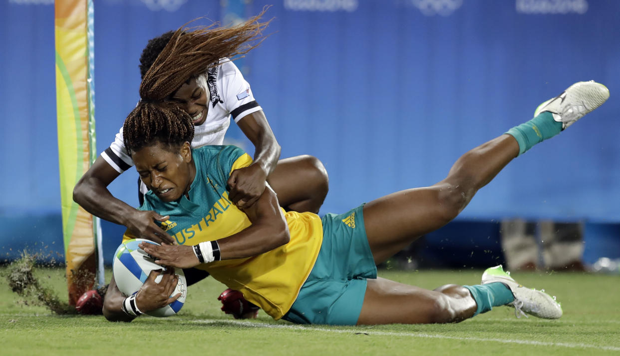 FILE - Australia's Ellia Green, front, scores a try as Fiji's Raijieli Daveua, tries to defend during the women's rugby sevens match between Australia and Fiji at the Summer Olympics in Rio de Janeiro, Brazil, Saturday, Aug. 6, 2016. Green, one of the stars of Australia's gold medal-winning women's rugby sevens team at the 2016 Olympics, has transitioned to male. The 29-year-old, Fiji-born Green is going public in a video at an international summit aimed at ending transphobia and homophobia in sport. The summit is being hosted in Ottawa as part of the Bingham Cup rugby tournament. (AP Photo/Themba Hadebe, File)