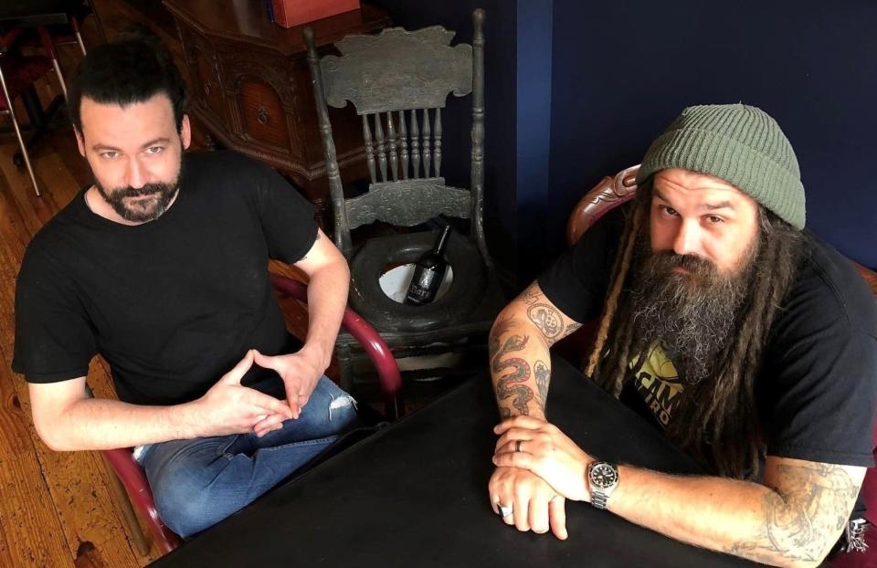 On the right, seated at a table overlooking N. Sycamore St. in Old Towne Petersburg, Oyster Society co-owner Chef Ernie LaBrecque of Petersburg strikes a pose with Bartender Eli Dwyer of Richmond.