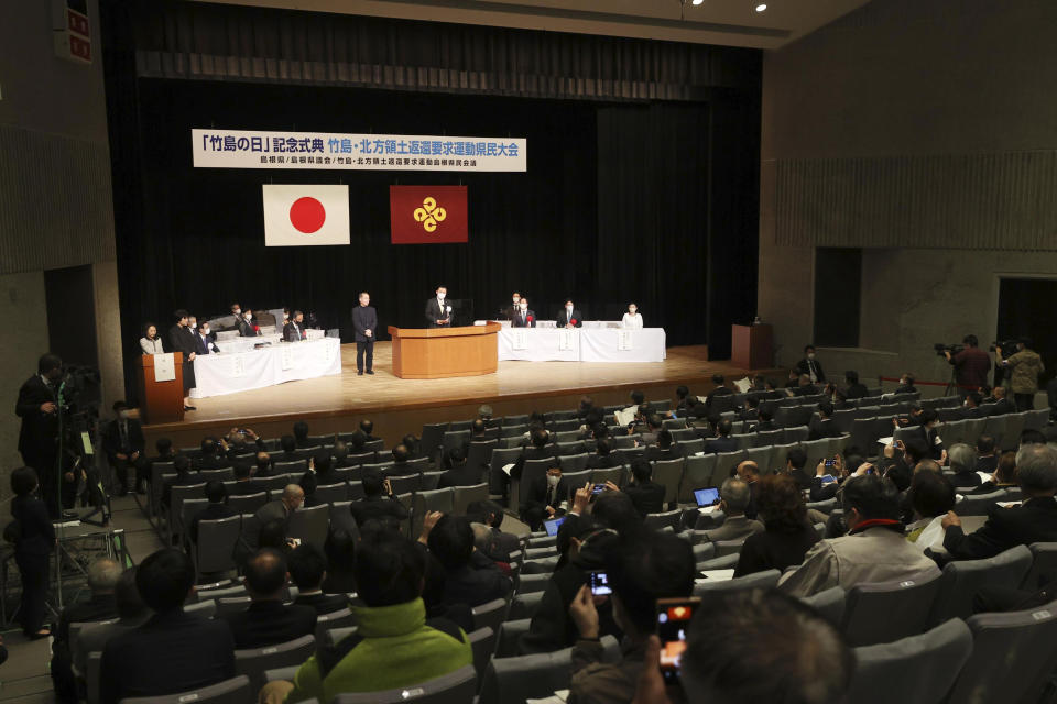 Shimane Gov. Tatsuya Maruyama, center, delivers a speech during a ceremony to mark Shimane Prefecture-designated "Takeshima Day" in Matsue, Shimane prefecture, western Japan, Monday, Feb. 22, 2021. Japan renewed its claim on a contested island in the Sea of Japan held by South Korea at the annual event Monday, escalating tensions between the neighbors were already strained over Seoul's compensation claim over Tokyo's World War II atrocities. The island is called "Takeshima" in Japan and "Dokdo" in South Korea. (Kyodo News via AP)