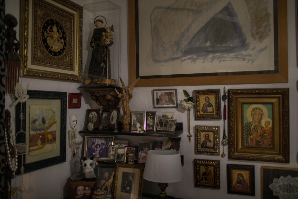 Religious elements decorate a bedroom at Joan Olmedillo's home in Barcelona, Spain, April 2, 2020. Olmedillo received a house call from visiting nurse Laura Valdes during the coronavirus pandemic. (AP Photo/Emilio Morenatti)