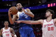 FILE -Minnesota Timberwolves center Rudy Gobert, center, pulls in a rebound between Houston Rockets forward Jabari Smith Jr. (10) and center Alperen Sengun (28) during the first half of an NBA basketball game Friday, Jan. 5, 2024, in Houston. Rudy Gobert wins record-tying 4th Defensive Player of the Year award, Tuesday, May 7, 2024. (AP Photo/Michael Wyke, File)