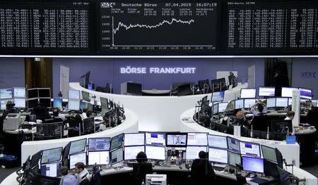Traders are pictured at their desks in front of the DAX board at the Frankfurt stock exchange April 7, 2015. REUTERS/Staff/remote