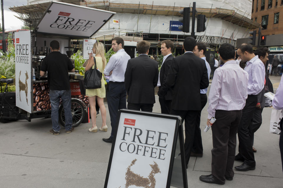Lunchtime city workers queue for freebie coffee courtesy of The Economist magazine. With the promise of a freebie, the waiting crowd line up near a sign telling passers-by they can enjoy a hot beverage provided by the Financial and News magazine published in London. The marketing and PR plan seems to be working for this publication, eager to promote their brand with a free copy and a limited subscription sign-up period. (Photo by In Pictures Ltd./Corbis via Getty Images)