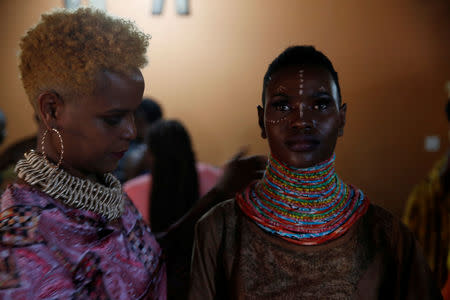 A model receives final touches behind the scenes of a fashion show featuring African fashion and culture during a gala marking the launch of a book called "African Twilight: The Vanishing Rituals and Ceremonies of the African Continent" at the African Heritage House in Nairobi, Kenya March 3, 2019. REUTERS/Baz Ratner