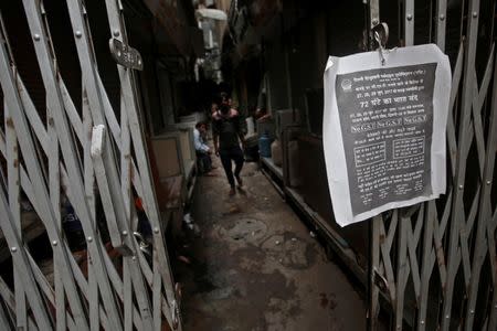 A poster is hanged at the entrance of a closed garments market during a protest against the implementation of the goods and services tax (GST) on textiles, in the old quarters of Delhi, India June 29, 2017. REUTERS/Adnan Abidi