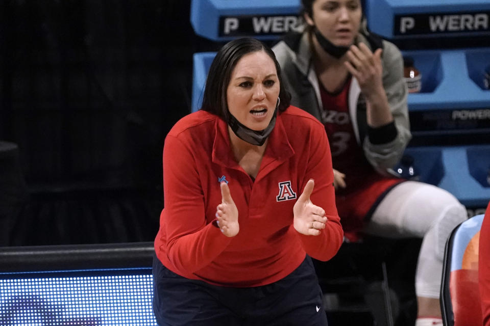 Arizona head coach Adia Barnes applauds her team during the first half of a women's Final Four NCAA college basketball tournament semifinal game against Connecticut Friday, April 2, 2021, at the Alamodome in San Antonio. (AP Photo/Morry Gash)