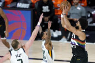 Denver Nuggets' Jamal Murray, right, shoots against Utah Jazz's Joe Ingles, left, and Jordan Clarkson during overtime in an NBA basketball first round playoff game, Monday, Aug. 17, 2020, in Lake Buena Vista, Fla. The Nuggets won 135-125 in overtime. (AP Photo/Ashley Landis, Pool)