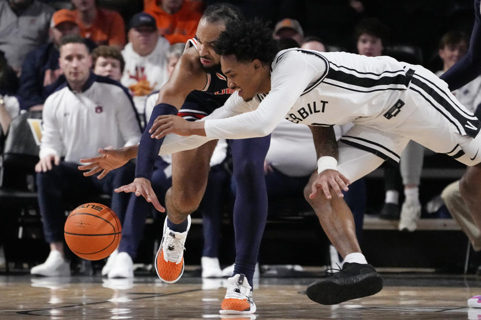 Auburn forward Johni Broome, left, and Vanderbilt guard Tyrin Lawrence dive for the ball during the first half of an NCAA college basketball game Wednesday, Jan. 17, 2024 in Nashville, Tenn. (AP Photo/George Walker IV)