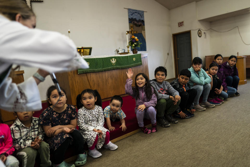 The Rev. Anna Silco, a co-pastor of the Shishmaref Lutheran Church with her husband, Aaron, interacts with children while showing them mustard seeds during a Sunday service in Shishmaref, Alaska, Sunday, Oct. 2, 2022. The tight-knit, resilient community continues to maintain their traditions and celebrate birthdays, baptisms and graduations centered around their homes, the local school and one of the world’s northernmost Lutheran churches. (AP Photo/Jae C. Hong)