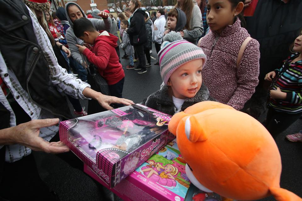 Five-year-old Raven Nichols looks back at his family as she receives an armful of gifts during the 27th annual Gaston County Toy Run for Kids which kicked off Saturday morning, Dec. 3, 2022, at the Ranlo Church of God.