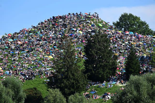 <p>Getty</p> Fans sit on the Olympiaberg in the Olympiapark ahead of Taylor Swift's Eras Tour show in Munich