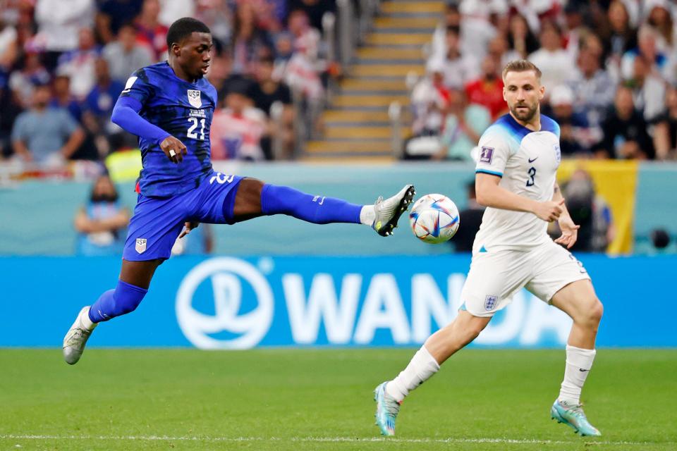 November 25, 2022: United States of America forward Timothy Weah (21) kicks the ball against England defender Luke Shaw (3) during the second half of a group stage match during the 2022 World Cup at Al Bayt Stadium.