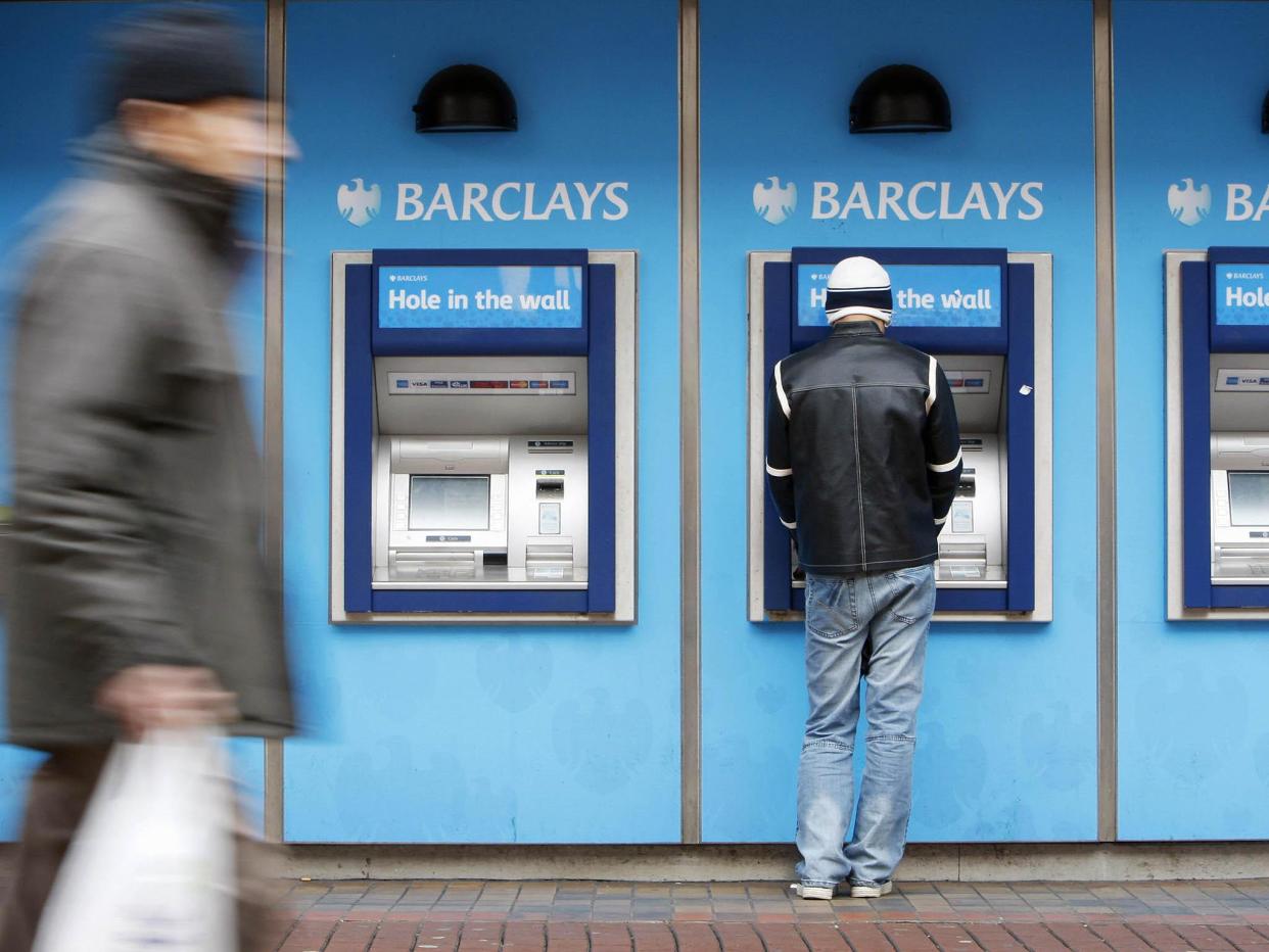 A man uses a cashpoint machine at a Barclays Bank branch in Hounslow, west London: Getty