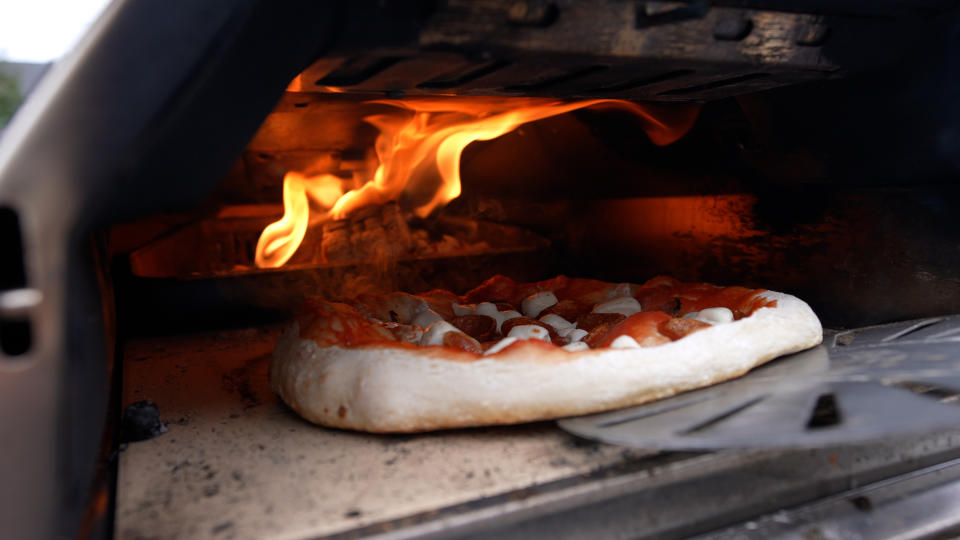 putting a pizza into the oven