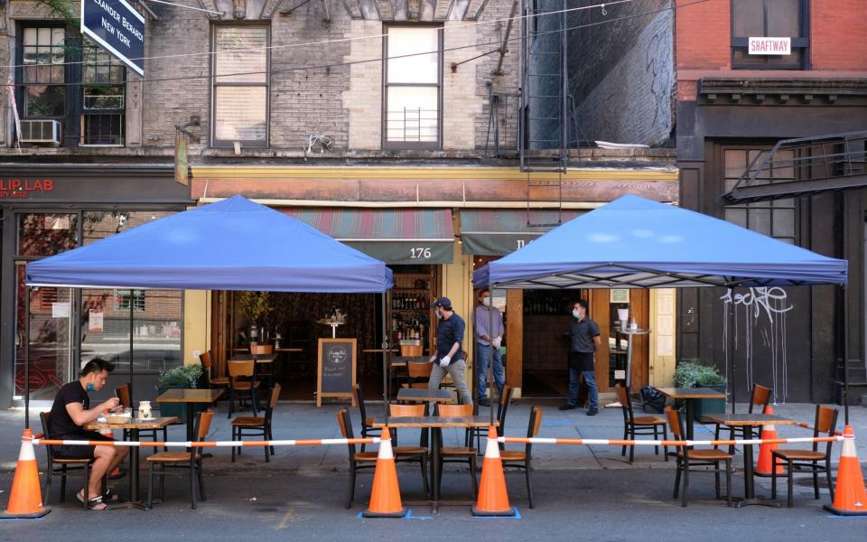 A restaurant in SoHo serves customers seated at sidewalk tables as New York moves into Phase 2 of re-opening following restrictions - Getty