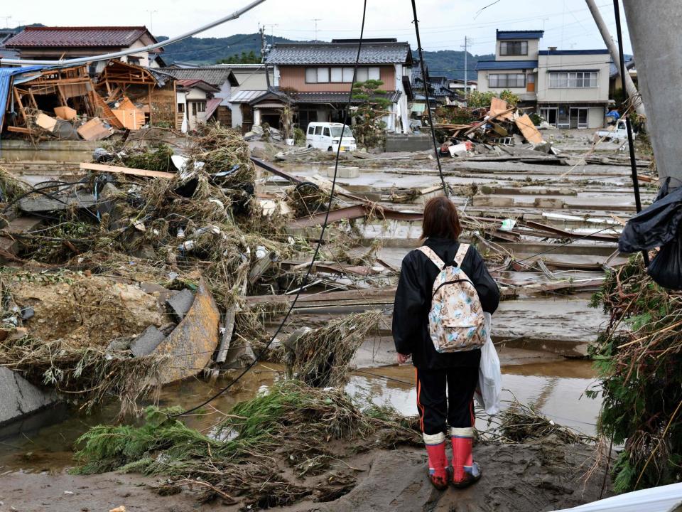 A woman looks at flood-damaged homes in Nagano after Typhoon Hagibis: Getty