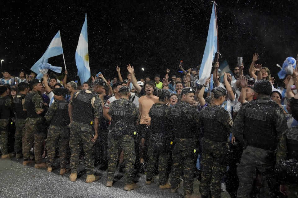 Fans wait for the arrival of the the Argentine soccer team that won the World Cup outside the AFA training grounds in Buenos Aires, Argentina, Tuesday, Dec. 20, 2022. (AP Photo/Matilde Campodonico)