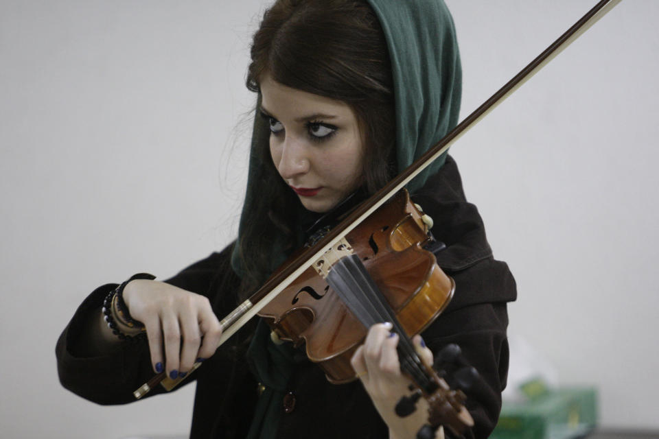 In this picture taken on Friday, Feb. 1, 2013, female Iranian violinist Nastaran Ghaffari practices for her band called "Accolade" in a basement of a house in Tehran, Iran. Heavy metal guitarists jamming in basements. Headphone-wearing disc jockeys mixing beats. Its an underground music scene that is flourishing in Iran, despite government restrictions. (AP Photo/Vahid Salemi)