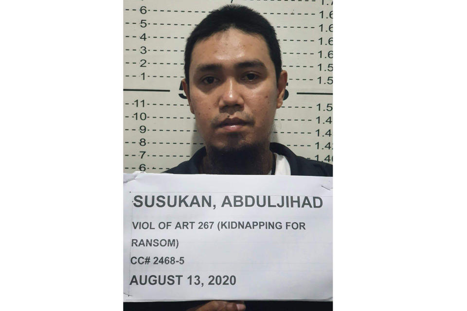 In this photo provided by the Philippine National Police-Public Information Office, Abu Sayyaf commander Anduljihad Susukan poses for a picture at the Davao City Police Station in Davao province, southern Philippines on Thursday Aug. 13, 2020. Susukan, a leading terror suspect who has been linked to beheadings of hostages including two Canadians and a Malaysian, has surrendered after being wounded in battle, officials said Friday. (Philippine National Police PIO via AP)